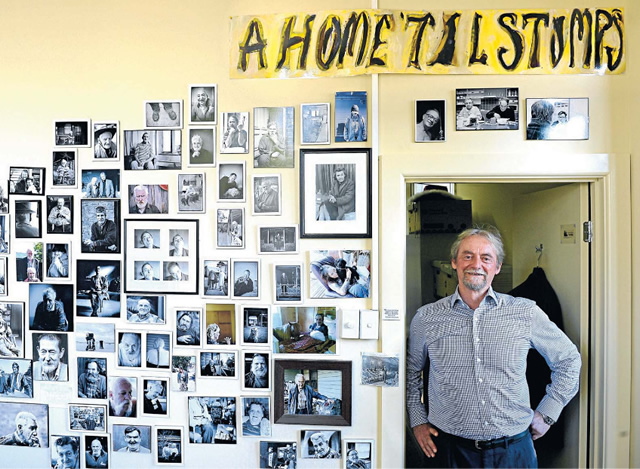 Dedicated: Bryan Lipmann in his office at Wintringham Aged Care. He founded Wintringham to support elderly homeless people, some of whom are pictured on the wall. Photo: Penny Stephens